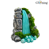 Decorative aquarium waterfall with rocks and greenery on a white background