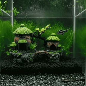 Decorative aquarium scene with lush green plants, colorful fish, a small bridge, and natural rock formations creating a peaceful aquatic landscape.